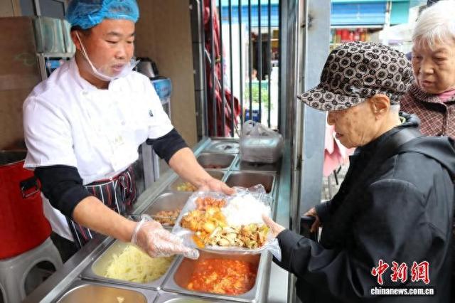 图为西安一社区慈善食堂内老年人前来就餐。 李一璠 摄
