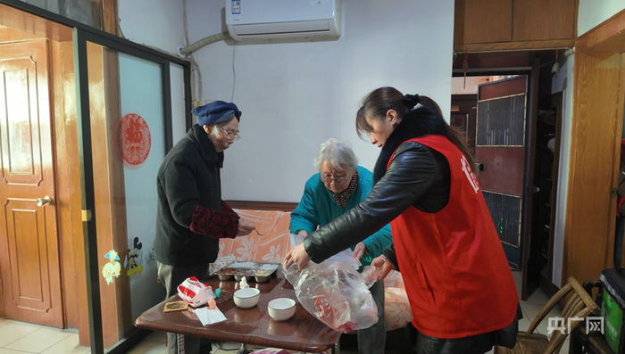 邹伟红为黄梦龙、曹修信两位老人送餐上门（央广网记者黄珂岚 摄）